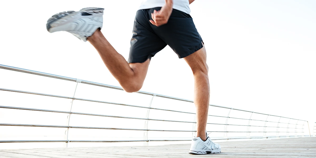 Man running on a boardwalk by the ocean
