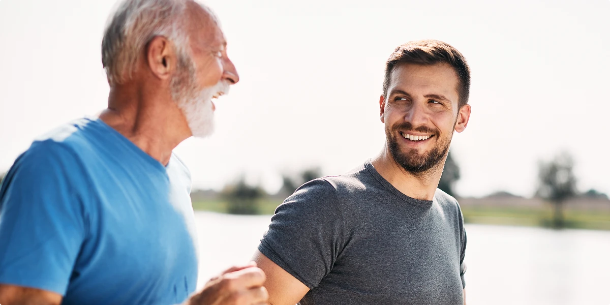 Father and adult son walking outdoors to support heart health and long term longevity