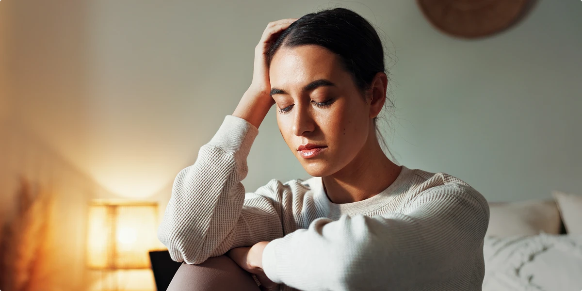 Woman sitting at home looking exhausted and experiencing unexplained fatigue
